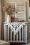 White lace runner, vintage books, and dried florals on a shuttered radiator cover in cozy DIY Shabby Chic Décor style.