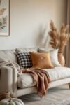 Modern Beige Living Room: Amazing Ways to Wow Guests Modern beige living room with cozy fall accents, textured pillows, soft blankets, and pampas grass in a neutral ceramic vase.