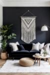 Bold macramé tapestry on a black wall behind a velvet couch, blending drama and boho wall art ideas.