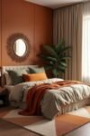 Cozy bedroom with green pillows and throw blanket, showcasing burnt orange bedroom color combinations and warm lighting.