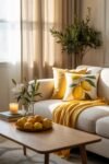 Cozy living room with a lemon-themed throw pillow, yellow blanket, and a bowl of fresh lemons on a wooden coffee table.