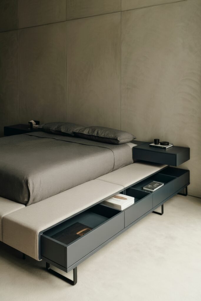 Masculine Luxury Bedroom: Genius Luxe Ideas 18 Sleek and minimal bedroom with matte taupe walls, low-profile bed with gray bedding, and a modern bench featuring built-in storage and light-toned seating.