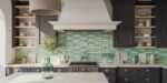 Stylish kitchen with dark cabinetry, light countertops, and glossy green tile backsplash, featuring a central gas stove, open shelving with decor, and a large vent hood framed by black kitchen cabinets.