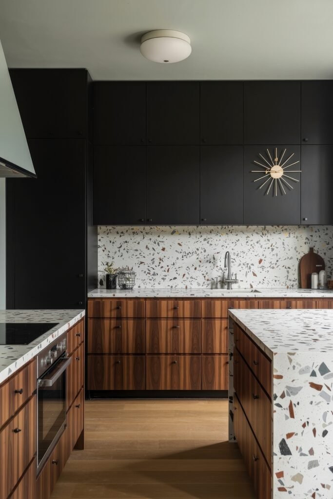 Stunning Ways to Style Black Kitchen Cabinets 23 Modern kitchen with upper black cabinets and lower wood grain drawers, terrazzo countertops and backsplash, and a sunburst clock adding a touch of mid-century flair.