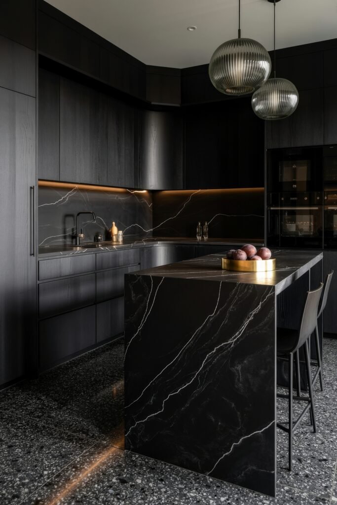 Chic Ways to Style a Modern Black Kitchen 21 Luxurious modern black kitchen with sleek matte cabinetry, dramatic black marble island and backsplash, under-cabinet lighting, and terrazzo flooring under pendant globe lights.