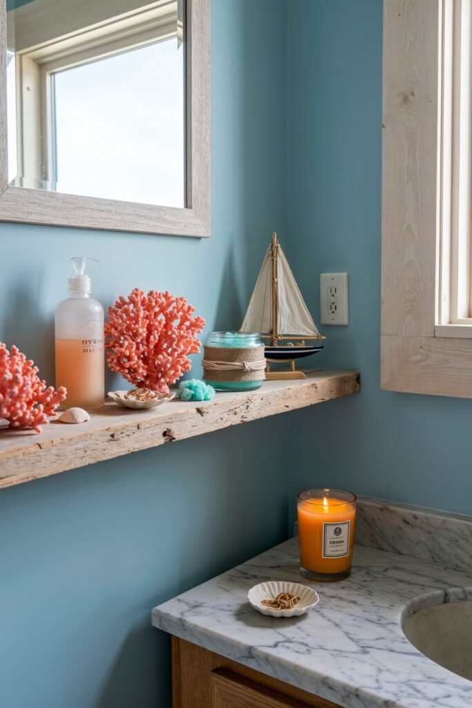 Gorgeous Ways to Elevate Your Bathroom Shelf Decor 27 Nautical-themed bathroom with a weathered wood shelf styled with coral, a small sailboat, seashells, and a wrapped jar candle, set against soft blue walls and a marble vanity top for a breezy ocean-inspired look.