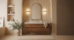 Minimalist bathroom featuring warm neutral tones, a floating wooden vanity with a marble countertop, an arched mirror, ribbed wall texture, and soft lighting—an elegant example of modern bathroom decor ideas.