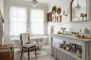 Elegant bathroom with a clawfoot tub, marble vanity, vintage portraits on the wall, and soft natural light creating a french vintage bathroom décor.