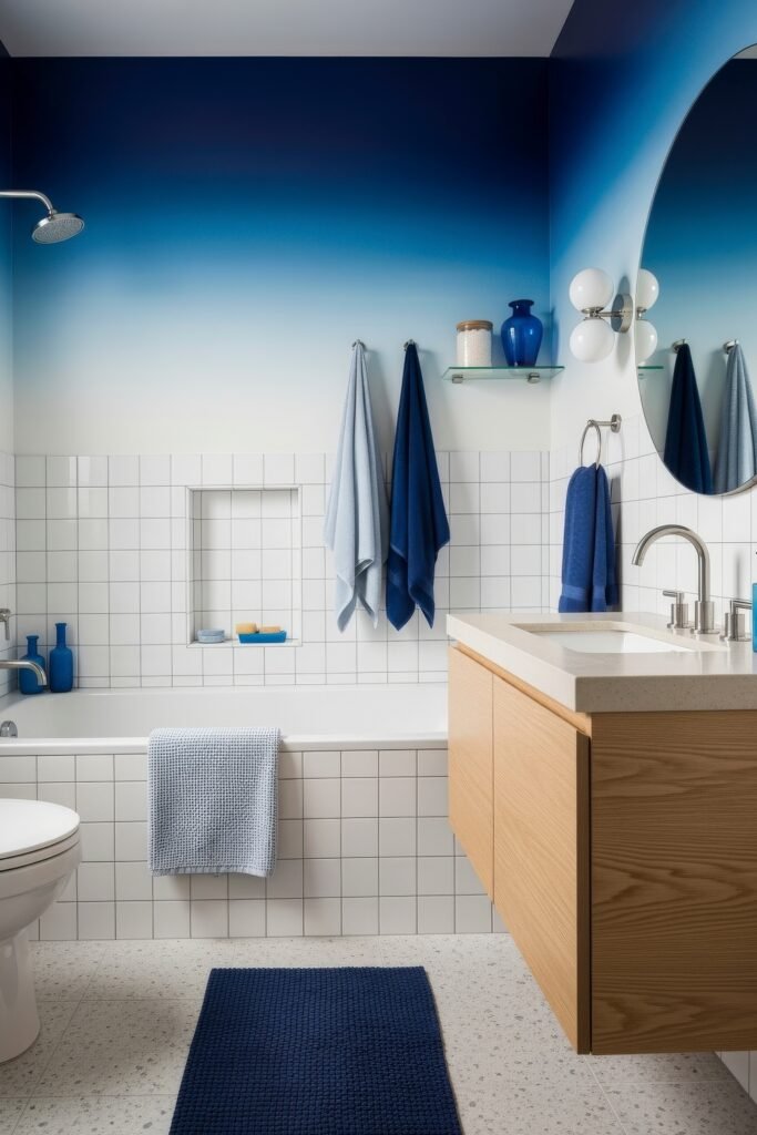 Blue Bathroom Decor: Fresh, Wow-Worthy Ideas 15 Stylish bathroom with ombre blue wall, white tile tub, and wood vanity accented by layered blue towels and rug.