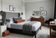 Effortlessly Stylish bedroom ideas for men That Feel Personal 257 Sophisticated bedroom with a gray upholstered headboard, layered bedding, warm wood furniture, and modern lighting, offering refined bedroom ideas for men.