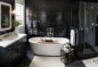 Stylish black and white bathroom decor featuring glossy black subway tiles, a freestanding white tub with a wooden tray, a glass-enclosed shower, and a sleek black vanity with a white countertop.