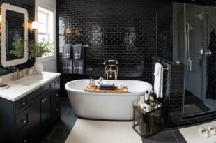 Stylish black and white bathroom decor featuring glossy black subway tiles, a freestanding white tub with a wooden tray, a glass-enclosed shower, and a sleek black vanity with a white countertop.