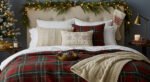 Elevate Your Bedroom with Cozy Christmas Bedding Bed styled with red and green plaid christmas bedding, knit throw blanket, and festive pillows, with garland, stocking, and candles creating cozy Christmas décor.