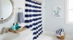 Small Changes, Big Smiles with funny bathroom decor Nautical bathroom decor with navy and white striped shower curtain, wicker baskets, and a mermaid wall art for a touch of funny bathroom decor.