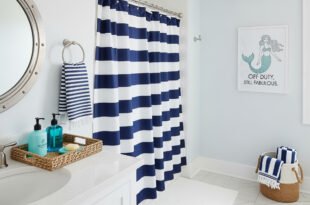 Nautical bathroom decor with navy and white striped shower curtain, wicker baskets, and a mermaid wall art for a touch of funny bathroom decor.
