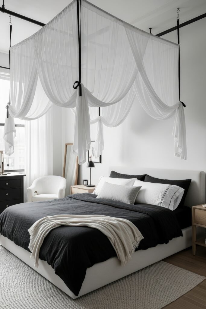Stylish room featuring a white bed with black bedding, canopy-style drapes, light wood nightstands, and a soft textured rug.