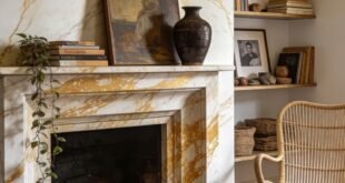 Cozy living room with a white and gold marble fireplace featuring brass sconces built in shelves a wicker chair and a rust velvet sofa
