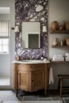Calacatta Viola Bathroom Ideas for a Richer Look Rustic bathroom vanity with curved wood cabinet and marble sink beneath a Calacatta Viola stone accent wall and open shelves with pottery and towels