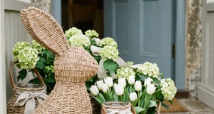 Woven bunny porch decor beside baskets of white tulips and hydrangeas at a blue front door