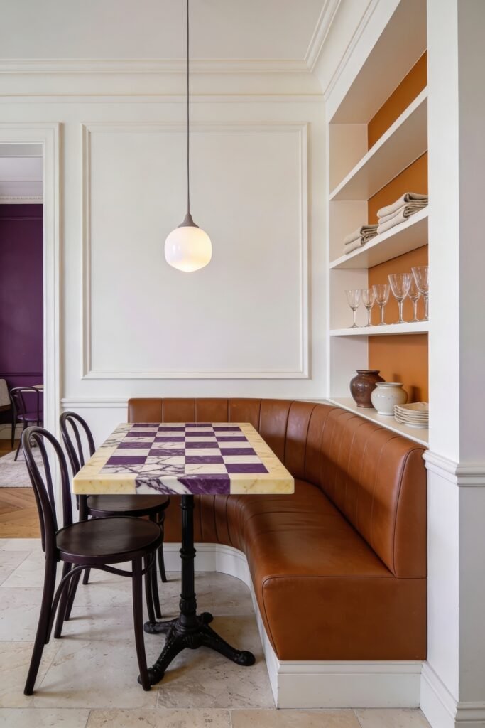 Breakfast nook with a caramel banquette and bentwood chairs around a checkerboard marble table beside open shelves