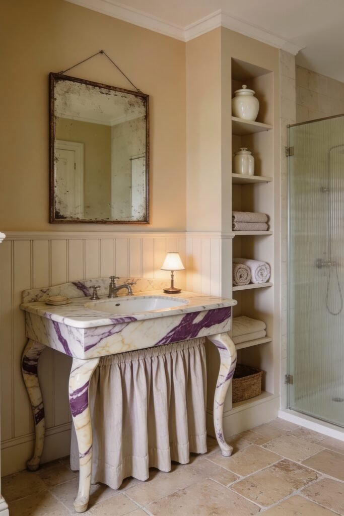 Calacatta Viola Bathroom Ideas for a Richer Look 6 Traditional bathroom vanity in Calacatta Viola marble with curved legs and fabric skirt beneath an antique mirror beside open shelving and shower