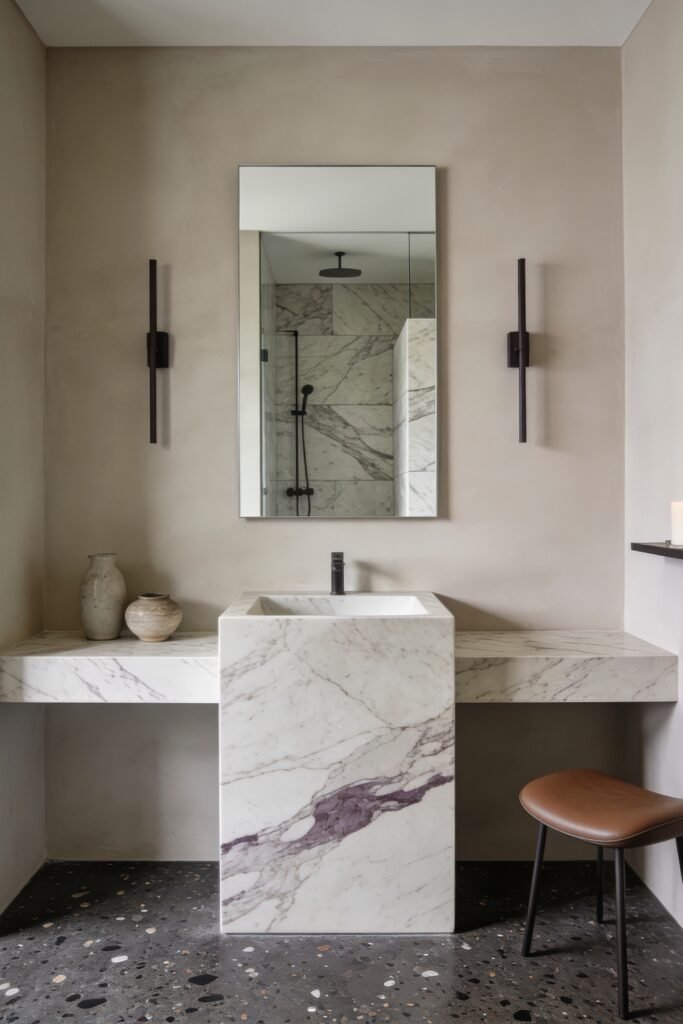 Calacatta Viola Bathroom Ideas for a Richer Look 9 Minimalist bathroom with Calacatta Viola marble pedestal sink beneath a frameless mirror and black sconces with terrazzo flooring