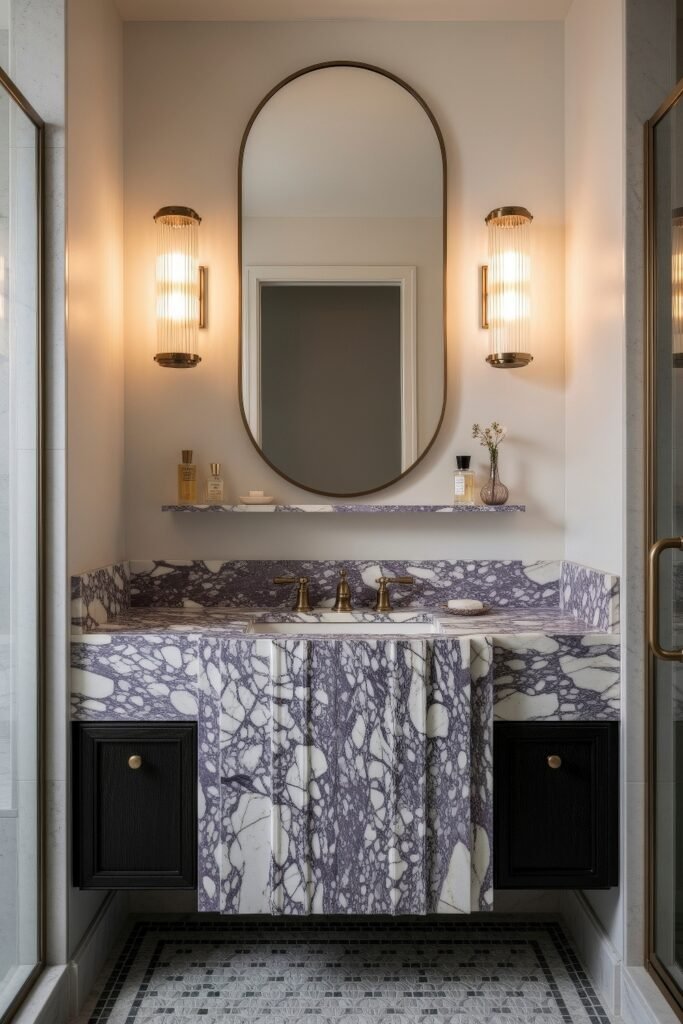 Calacatta Viola Bathroom Ideas for a Richer Look 14 Narrow marble bathroom vanity with Calacatta Viola stone sink warm brass fixtures and oval mirror framed by glowing ribbed sconces