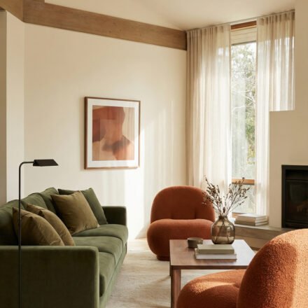Green Burnt Orange Living Room Ideas With Rich, Easy Style Olive green sofa with burnt orange boucle chairs, wood coffee table, beige rug, tall sheer curtains and fireplace in a warm Green Burnt Orange Living Room